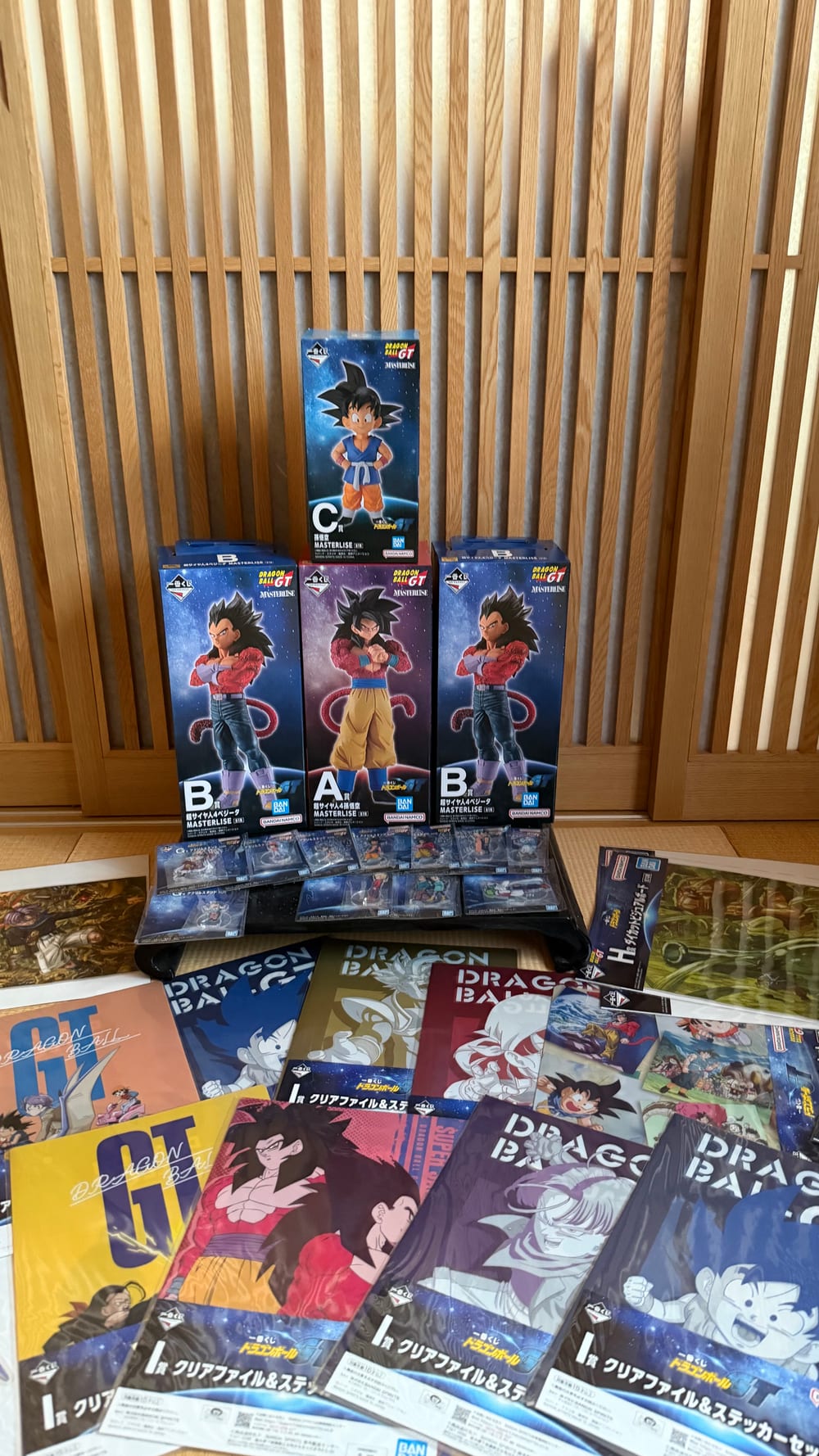 All of the Dragon Ball GT ichiban kuji prizes won that morning laid out together, boxed figures, acrylic stands and clear files